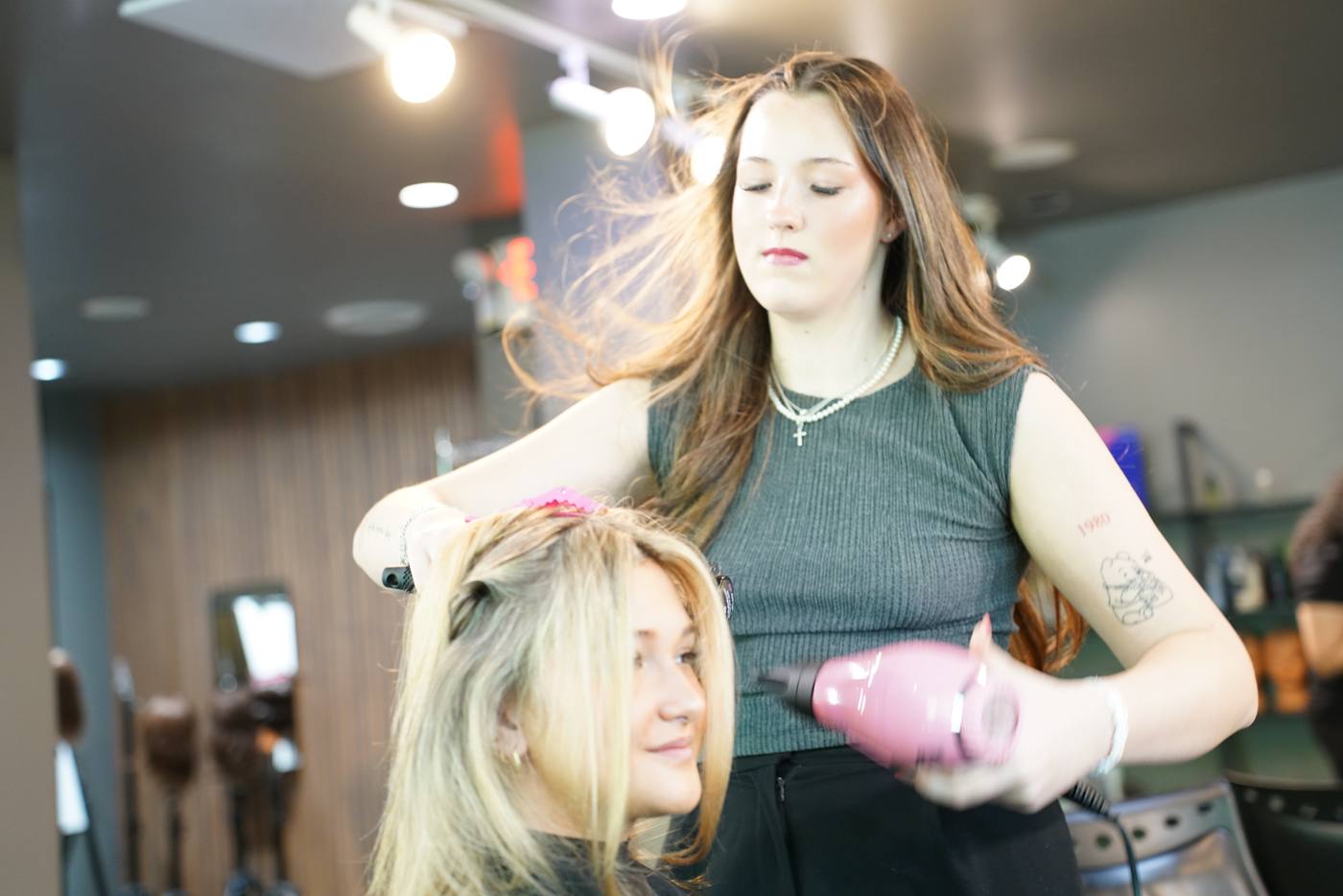 Student blow-drying hair at Aveda Institute Vancouver hairstylist program